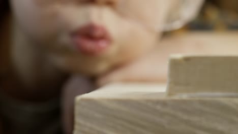 Cute-Boy-Blowing-Away-Sawdust