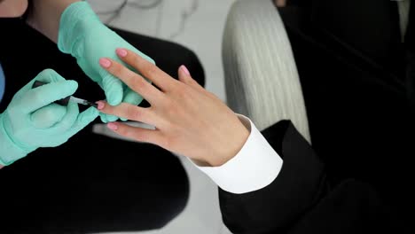 servicio-de-uñas,-las-manos-del-cliente-durante-la-pintura-de-uñas-en-salones-de-belleza-y-manicurista