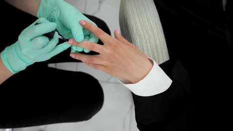 professionelle-Maniküre-in-Latex-Handschuhe-macht-Maniküre,-weiblich-im-Schönheitssalon