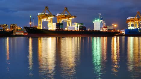 Time-Lapse-of-big-crane-loading-and-unloading-container-from-port-of-Bangkok-to-container-cargo-freight-ship-at-night-time.