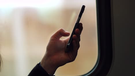 Hand-holding-up-cellphone-while-on-commute-from-work