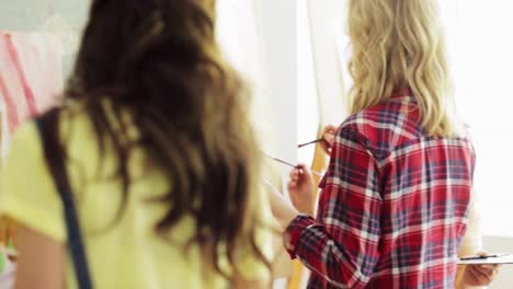 students-with-easels-painting-at-art-school