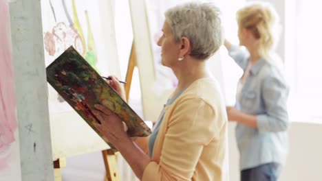 students-with-easels-painting-at-art-school