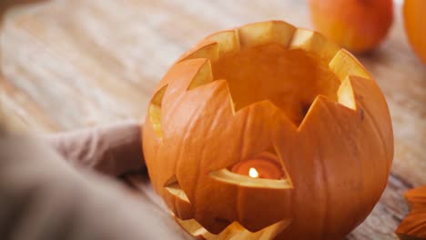 close-up-of-woman-with-halloween-pumpkin-at-home