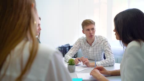 männliche-und-weibliche-Studenten-mit-Teamarbeit-Praxis-am-Tisch.