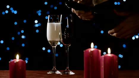 Pouring-champagne-into-a-glass-on-a-romantic-set