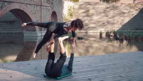 Beautiful-couple-practicing-acro-yoga-in-the-morning