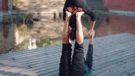 Schönes-paar-praktizieren-Acro-Yoga-am-Morgen