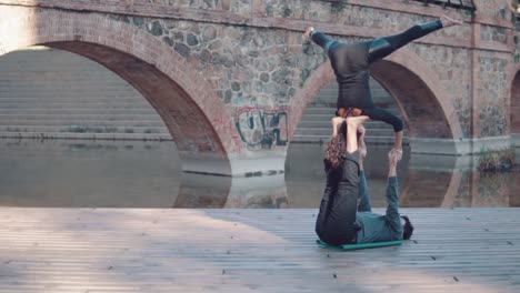 Beautiful-couple-practicing-acro-yoga-in-the-morning