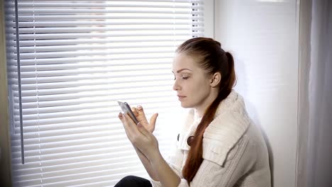 compras-en-línea,-una-mujer-joven,-viendo-los-productos-en-la-tienda-online-en-la-pantalla-del-smartphone