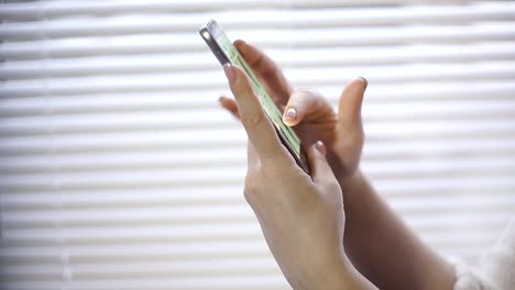 compras-en-línea,-una-mujer-joven,-viendo-los-productos-en-la-tienda-online-en-la-pantalla-del-smartphone