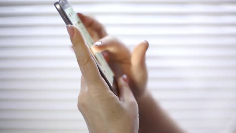 compras-en-línea,-una-mujer-joven,-viendo-los-productos-en-la-tienda-online-en-la-pantalla-del-smartphone