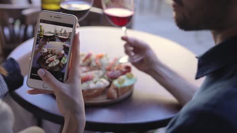 Closeup-Frau-Fotografieren-von-Essen-und-Wein-im-Restaurant.