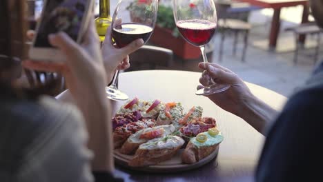 Closeup-Woman-Taking-Photos-On-Phone-Of-Food-In-Restaurant