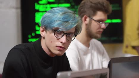 Young-Man-in-Glasses-Coding-on-Laptop