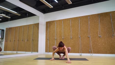 Young-woman-practicing-yoga-in-yoga-studio-with-free-space,-copy-space