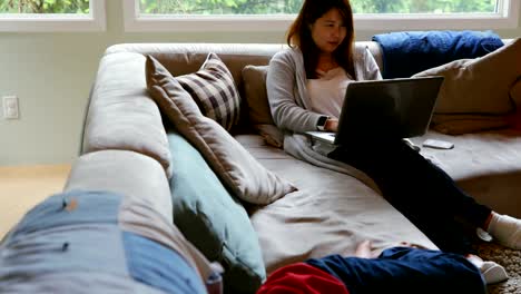 Mother-and-son-using-laptop-in-living-room-4k