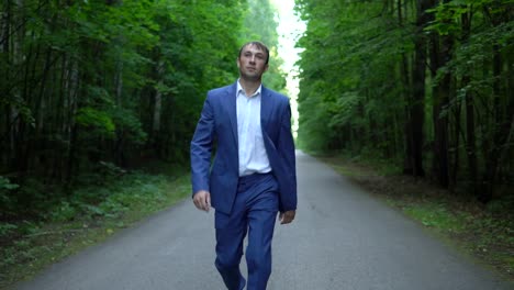 man-in-a-blue-suit-is-walking-along-the-road