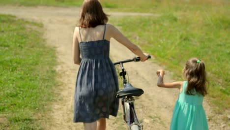 Mother-and-her-daughter-walking-along-a-rural-road