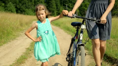 Mother-and-her-daughter-walking-along-a-rural-road