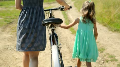 Mother-and-her-daughter-walking-along-a-rural-road