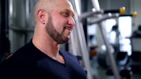 Adult-bodybuilder-straining-chest-muscles-and-smiling-4K-Slow-Mo