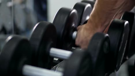 Close-up.-Men's-hands-take-big-dumbbells-4K-Slow-Mo