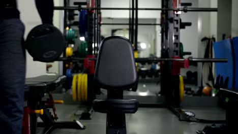 The-athlete-with-dumbbells-sits-on-a-bench,-does-an-exercise-for-two-hands-4K-Slow-Mo