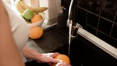 Washing-Fruits-With-Clean-Water-In-Kitchen-Closeup