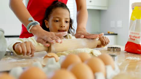 Black-mother-and-daughter-rolling-dough-with-rolling-pin-at-home-4k