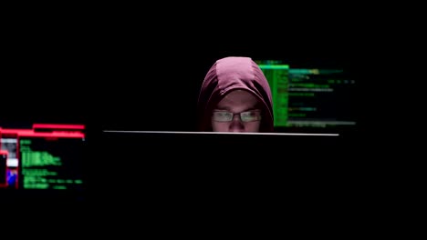 Man-with-a-hoodie-siting-in-the-data-computer-room-with-data-on-his-face