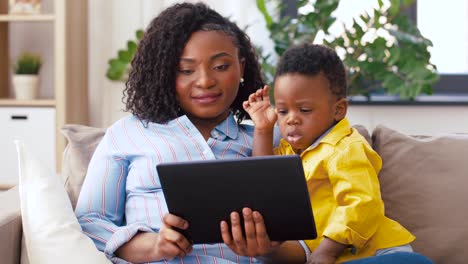 madre-usando-Tablet-PC-con-bebé-hijo-en-casa