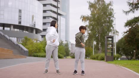 Asian-Mother-and-Son-Training-Outdoors-in-City-Center