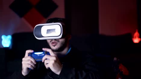 Männlicher-Spieler-setzt-VR-Brille-auf-den-Kopf-und-beginnt-mit-dem-Spielen-mit-Controller,-sitzend-auf-dem-Sofa