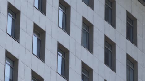 A-daytime-exterior-establishing-shot-of-apartment-buildings-on-a-sunny-summer-day.-Close-up-shot-of-modern-residential-building.-Residential-building-exterior-small-windows