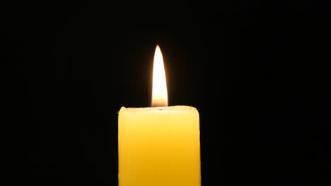 Quemadura-de-luz-de-las-velas-amarillo-brillante-en-negro