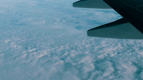 View-of-the-wing-of-an-airplane-in-flight-over-beautiful-air-clouds