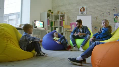 Little-Students-Listening-to-Male-Teacher-in-Kindergarten