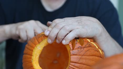 Mann,-die-komplexe-Konstruktion-auf-Halloweenkürbis-schnitzen