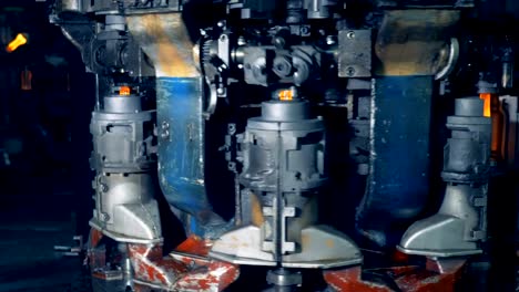 Factory-machine-melts-out-bottles,-speed-filming.