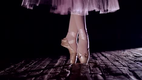 close-up,-in-rays-of-spotlight,-on-stage-of-old-theater-hall.-ballerina-in-white-skirt,-raises-on-toes-in-pointe,-performs-elegantly-a-certain-ballet-exercise,-pas-de-bourre-suivi