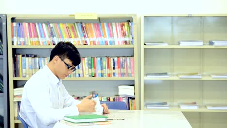 Lassen-Sie-uns-zusammenarbeiten,-um-unsere-Gruppe-Werk-zu-vollenden.-Junge-Studenten-forschen-gemeinsam-in-der-Bibliothek.-Chinesischen-jungen-und-Mädchen.