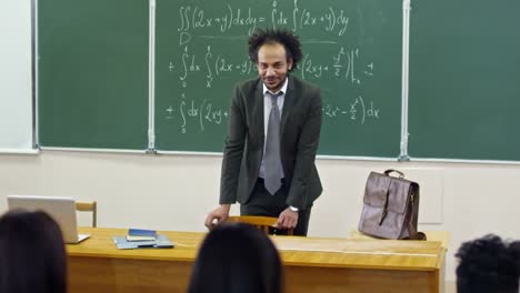 Amistoso-profesor-de-matemáticas-que-habla-a-los-estudiantes