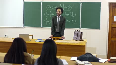 Profesor-de-matemáticas-en-pizarra-de-pie-durante-la-Conferencia