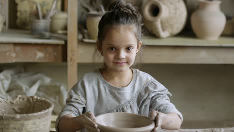 Niña-linda-haciendo-cerámica-y-posando