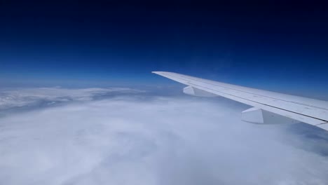 Airplane-wing-moving-above-white-clouds