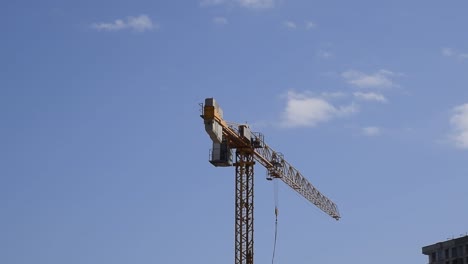 Tower-building-crane-against-the-blue-sky-and-sun.-Construction-of-new-buildings-with-a-crane.-Tower-crane.