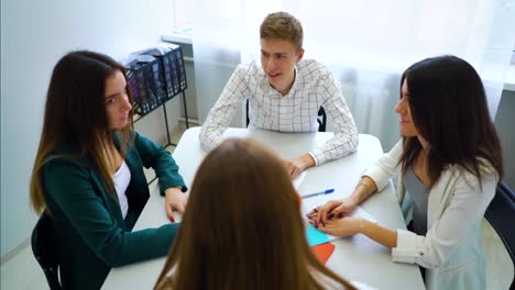 männliche-und-weibliche-Studenten-mit-Teamarbeit-Praxis-am-Tisch.