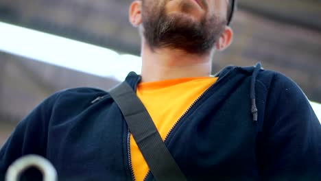 A-man-with-a-beard-in-glasses-walks-through-a-supermarket.-He-is-waiting-near-the-grocery-cart.