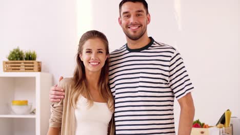 happy-couple-hugging-at-home-kitchen